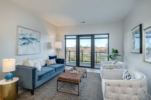 A living room with a grey couch, a coffee table, and a chair.