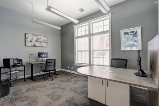 a conference room with desks and chairs and a large window