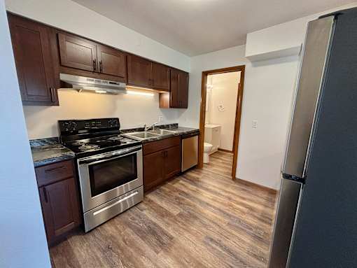 A kitchen with a stove top oven and a refrigerator.