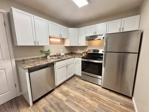 A kitchen with white cabinets and stainless steel appliances.