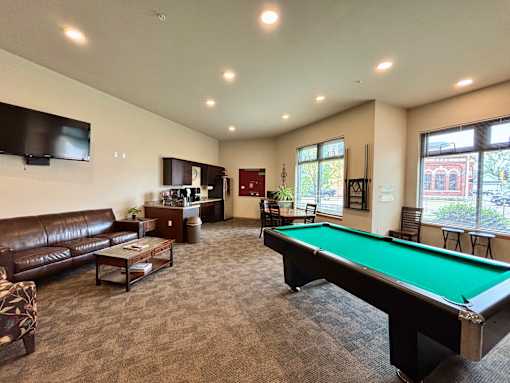 A room with a pool table and a couch.