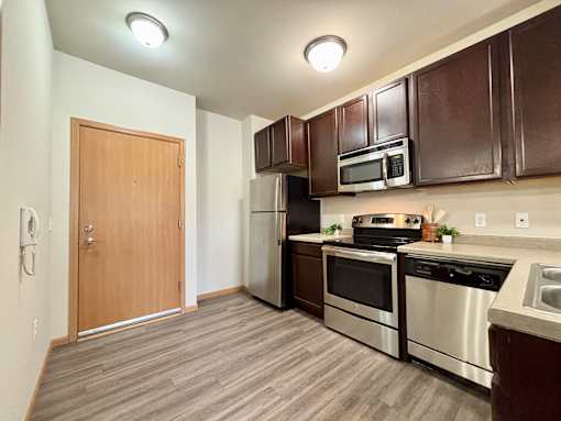 A kitchen with brown cabinets and stainless steel appliances.