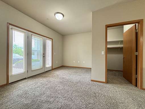 A room with a carpeted floor and a sliding glass door.