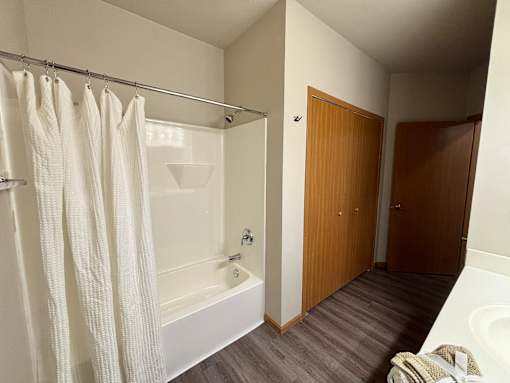 A bathroom with a white tub and a shower curtain.