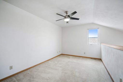 a room with white walls and a ceiling fan
