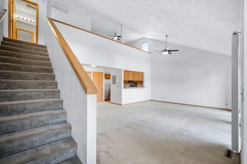 a living room with a staircase and a white wall