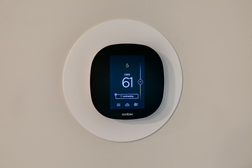 a digital thermostat on a white wall