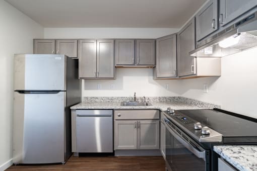 an empty kitchen with stainless steel appliances and granite counter tops