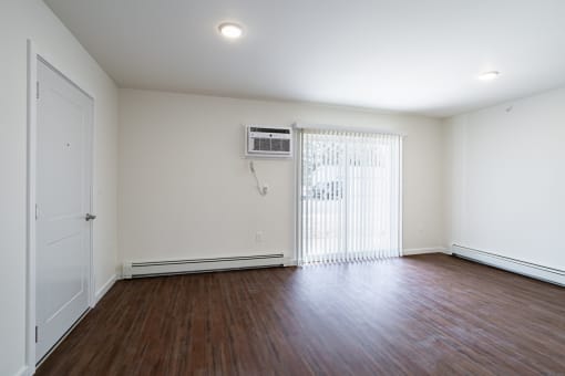 the living room of a home with a wood floor and white walls