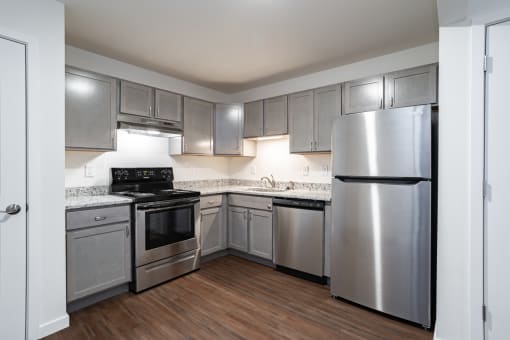 a kitchen with stainless steel appliances and white cabinets
