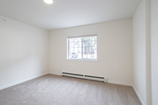 an empty room with white walls and a window