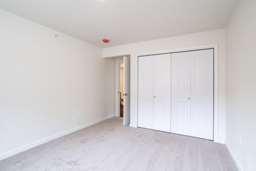 a bedroom with two closets and a door to a hallway