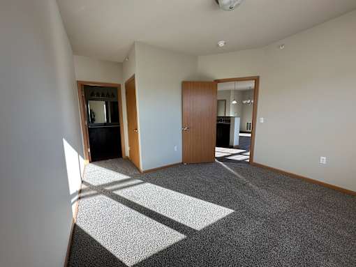 A room with a carpet and a door.
