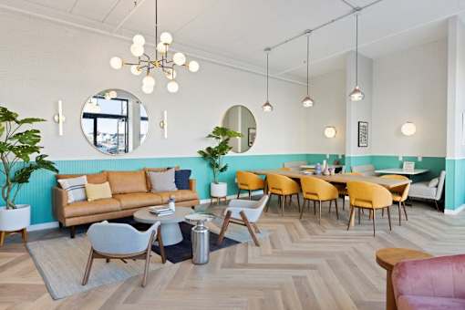 A room with a couch, chairs, and a table.