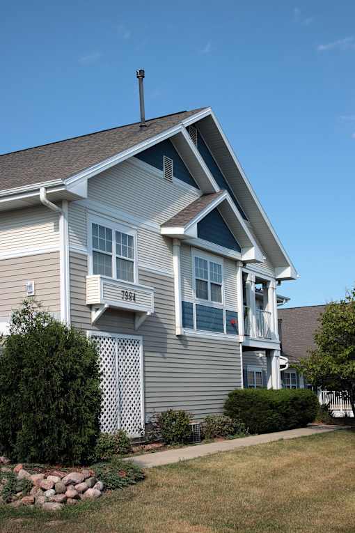 A house with a grey siding and a white trim.