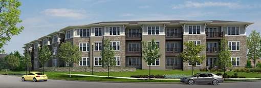 A modern apartment building with cars parked in front.