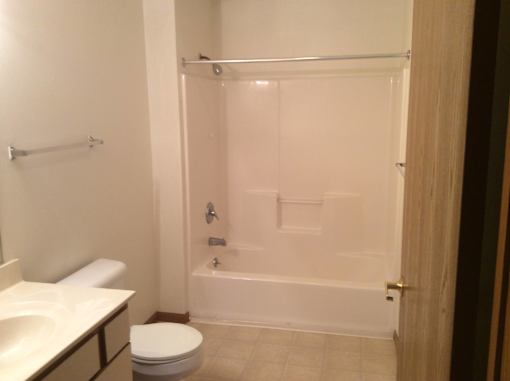 A white toilet sits next to a white sink in a bathroom.
