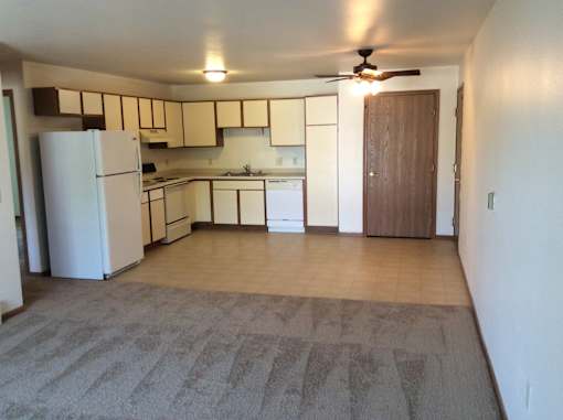 A kitchen with a white refrigerator and a ceiling fan.