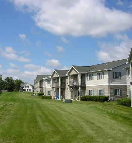 A row of houses with green lawns in front.