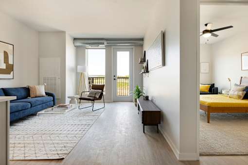 A living room with a blue couch and a yellow bed.