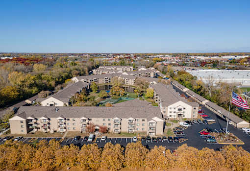 An aerial view of a large building complex with a parking lot in front.