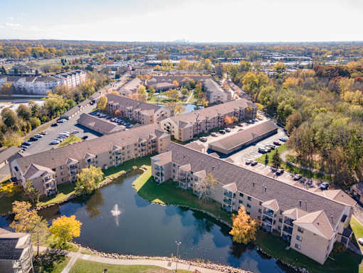 A large building complex with a pond in the foreground.