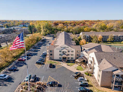 A parking lot with a building and an American flag in the foreground.