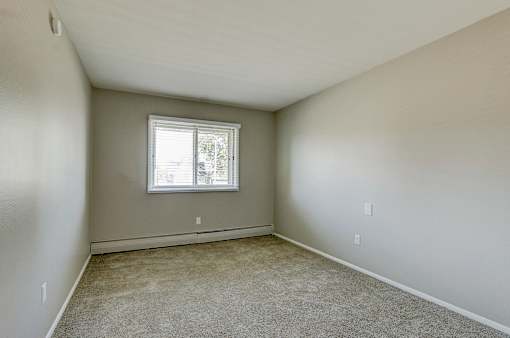 A room with a window and carpeted floor.