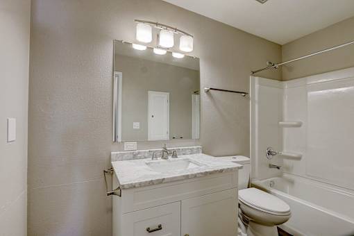A bathroom with a white toilet, sink, and bathtub.