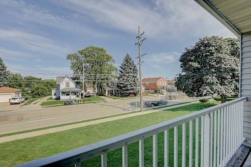 A view from a balcony overlooking a residential street.