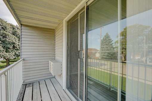 A sliding glass door with a screen on the side of a house.