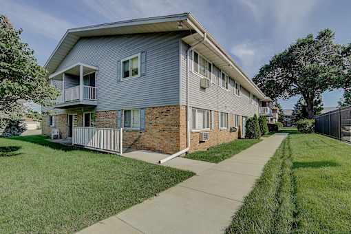 A two-story house with a balcony on the second floor.