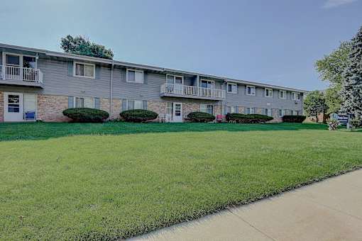 Apartment building with green lawn in front.