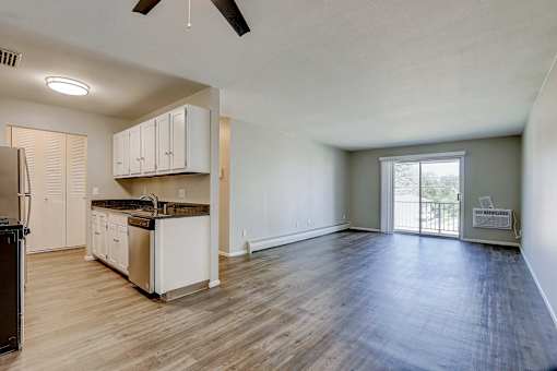 A kitchen with white cabinets and a black refrigerator.