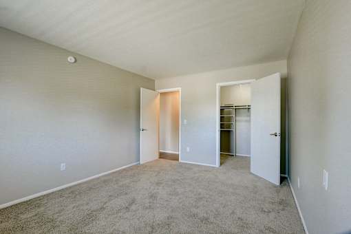 A large empty room with carpeted floor and white walls.