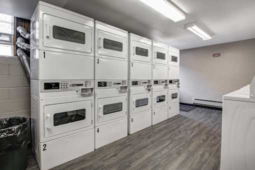 A row of white ovens are lined up in a room.