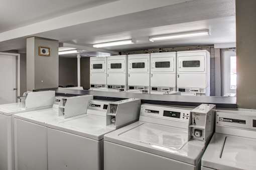 A row of white ovens are lined up in a room.