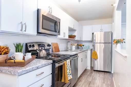 A modern kitchen with white cabinets and stainless steel appliances.
