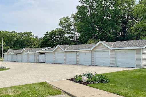 A long row of garages with trees in the background.