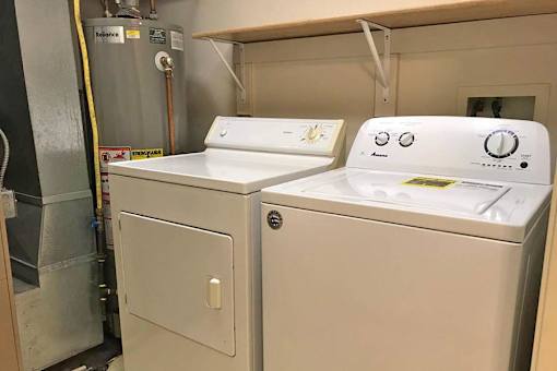 Two white washing machines in a small room.