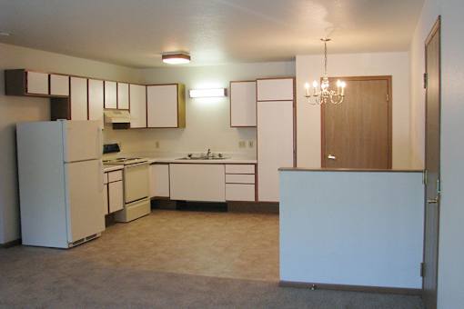 A kitchen with white appliances and cabinets.