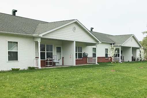 A white house with a red trim and a grey roof.