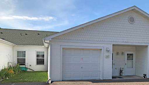 A white house with a garage door labeled 107.
