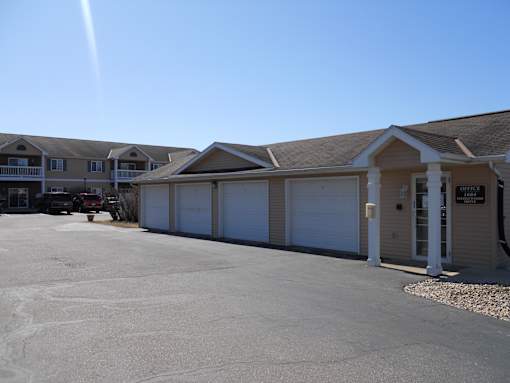 A sunny day at the outdoor parking lot of a building with multiple garages.