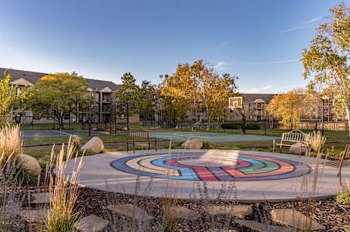 A colorful circular design is in the middle of a park.