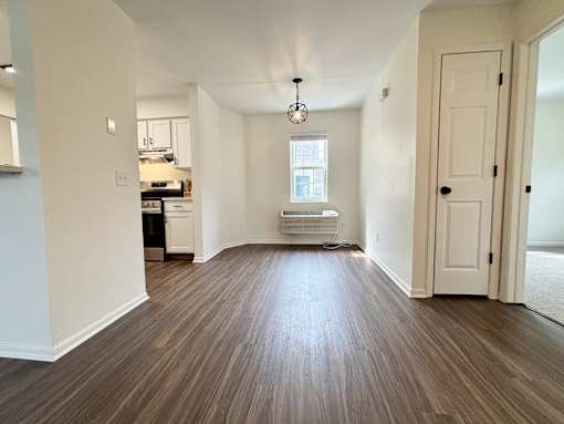 A room with wooden flooring and a white door.