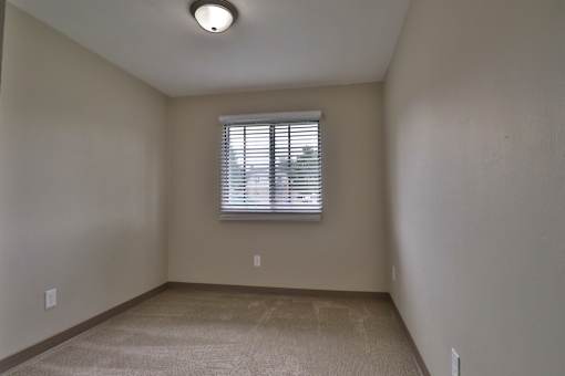 the spacious living room of an empty house with a window