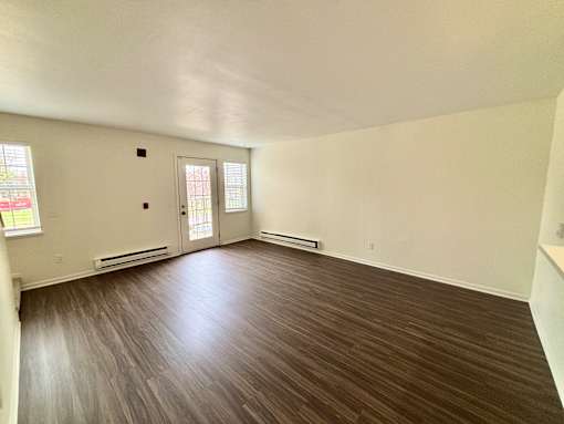 A room with a brown floor and white walls.