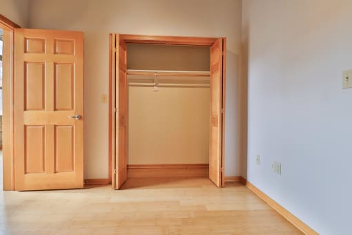 an empty room with a closet and a door open