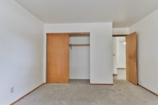 an empty room with a closet and a door in it